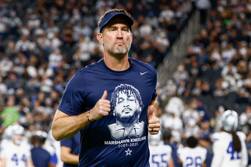 Dallas Cowboys head coach Brian Schottenheimer wears a Marshawn Kneeland shirt before an NFL...