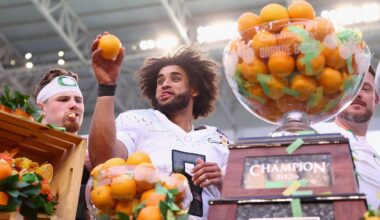 Oregon quarterback Dante Moore prepares to toss an orange after passing for 234 yards in the Orange Bowl win over Texas Tech.