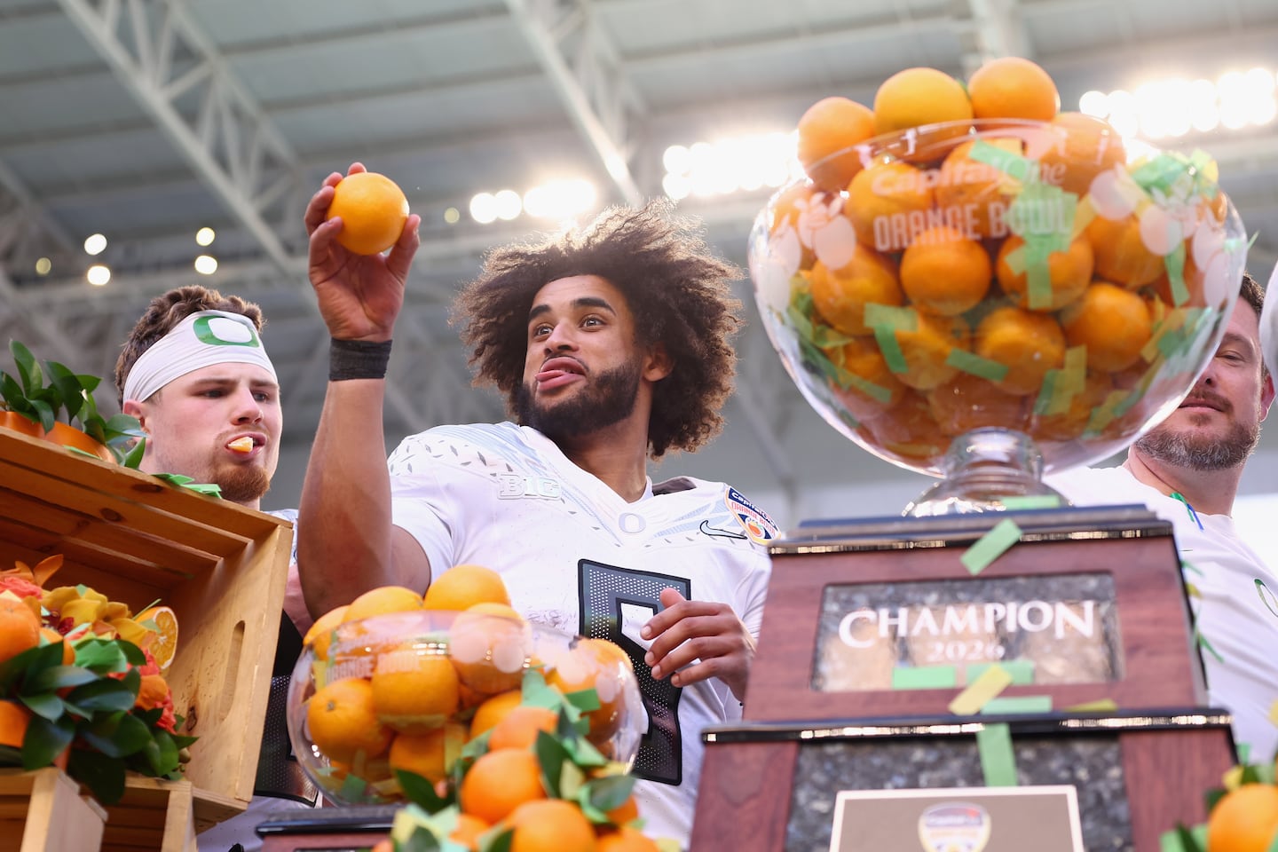 Oregon quarterback Dante Moore prepares to toss an orange after passing for 234 yards in the Orange Bowl win over Texas Tech.