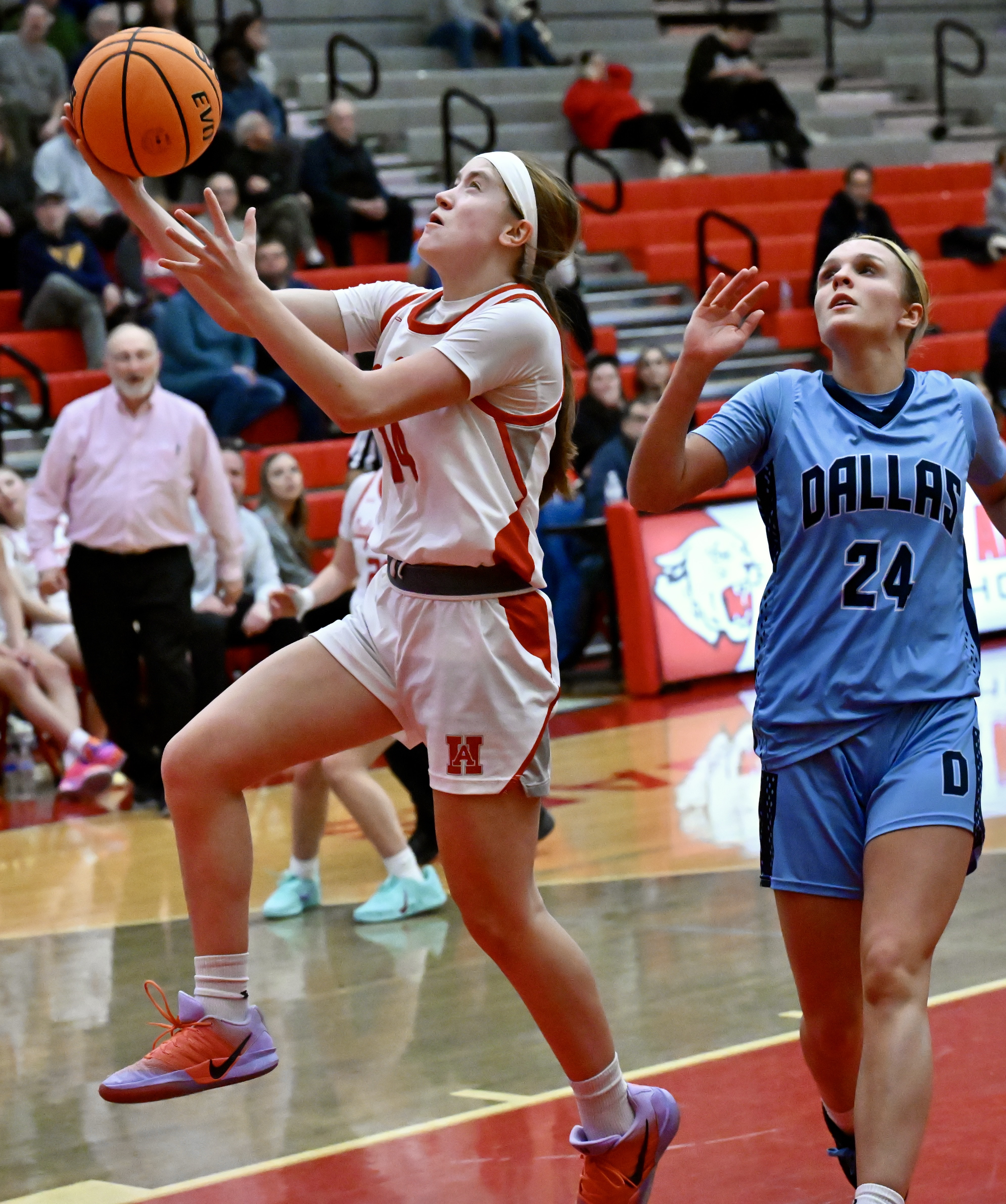Hazleton Area’s Kaitlyn Bindas (14) drives for a layup ahead...