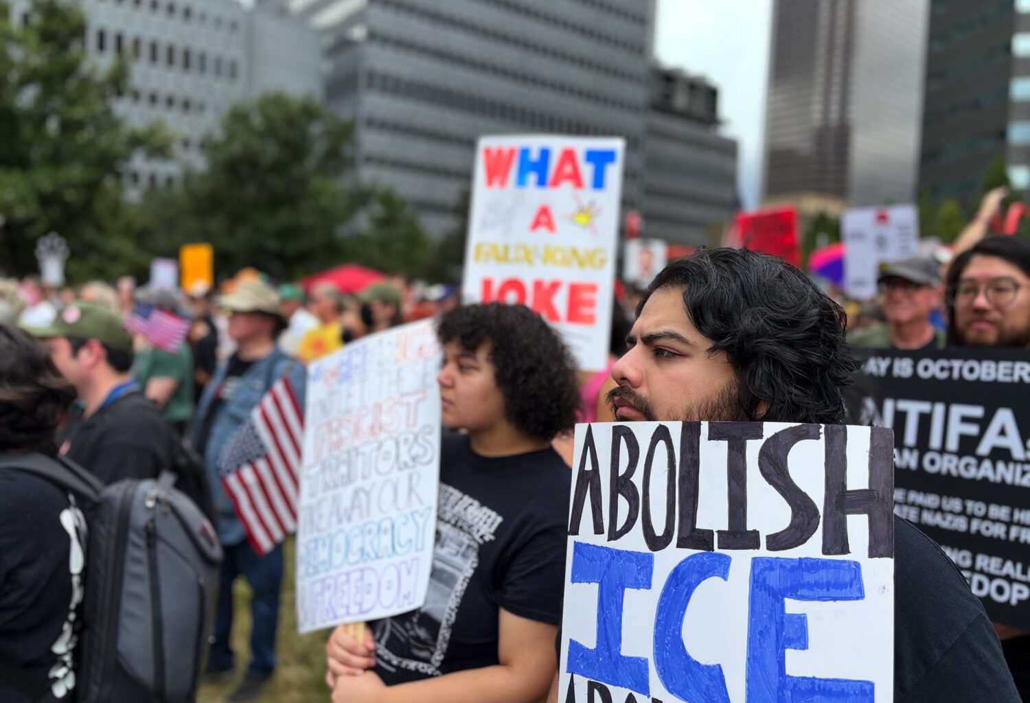 Man with sign calling to abolish ICE at Dallas No Kings protest.