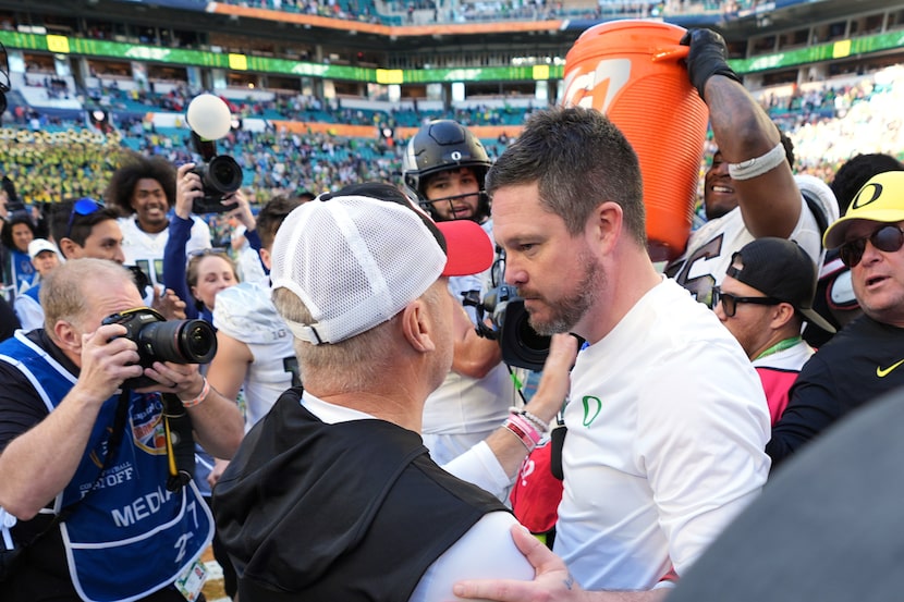 Oregon head coach Dan Lanning, center right, talks with Texas Tech head coach Joey McGuire...