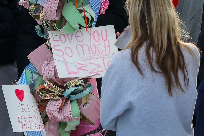 People gather around a makeshift memorial at the site where two girls were involved in...
