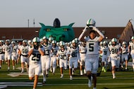 Southlake Carroll players runs onto the field before a high school football game against...