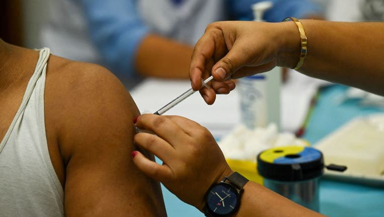 FILE - A health worker inoculates a man with a dose of the COVID-19 vaccine at a health centre in New Delhi on Oct. 21, 2021. (Photo by PRAKASH SINGH/AFP via Getty Images)