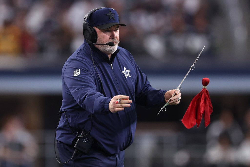  Mike McCarthy throws a challenge flag during the fourth quarter against the Washington Commanders at AT&T Stadium on January 05, 2025 in Arlington, Texas. 