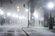 Blowing snow obscures people walking along Bryan Streen near the Pearl/Arts District station...