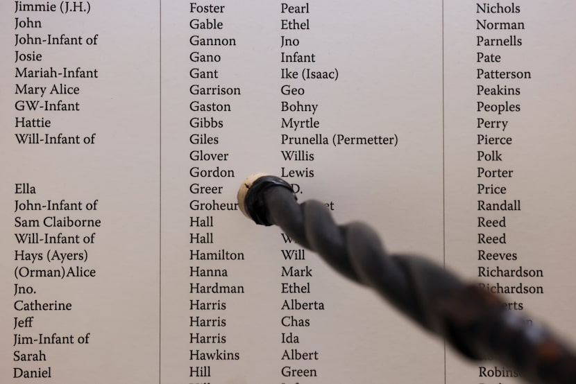 Professor Clarence Glover points out the name of his family member Willis Glover, among the...
