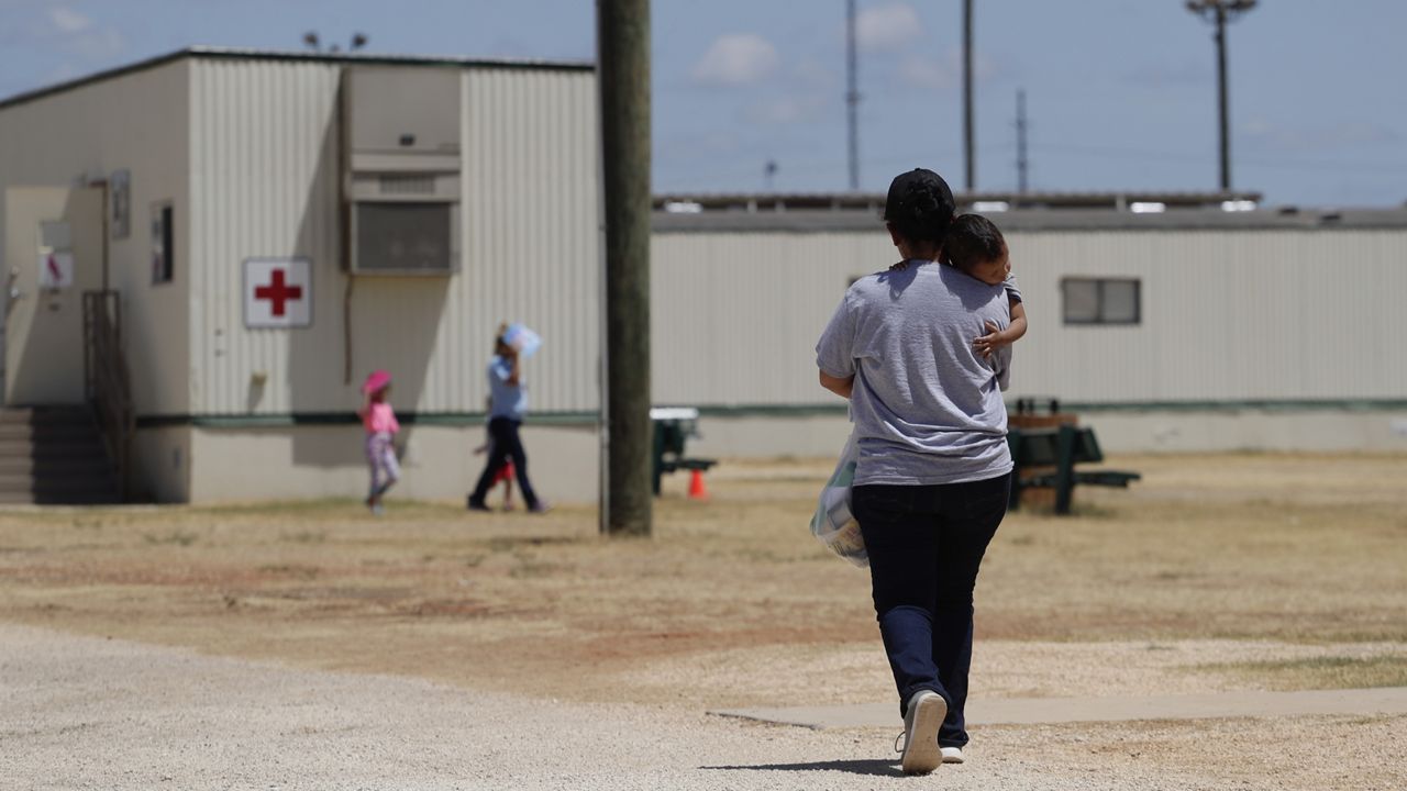 Immigrants seeking asylum walk at the ICE South Texas Family Residential Center, Aug. 23, 2019, in Dilley, Texas. (AP Photo/Eric Gay)