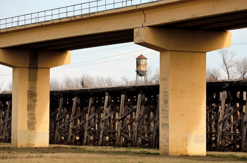 The old Atchison, Topeka & Santa Fe Trestle Bridge seen behind the DART line bridge over the...