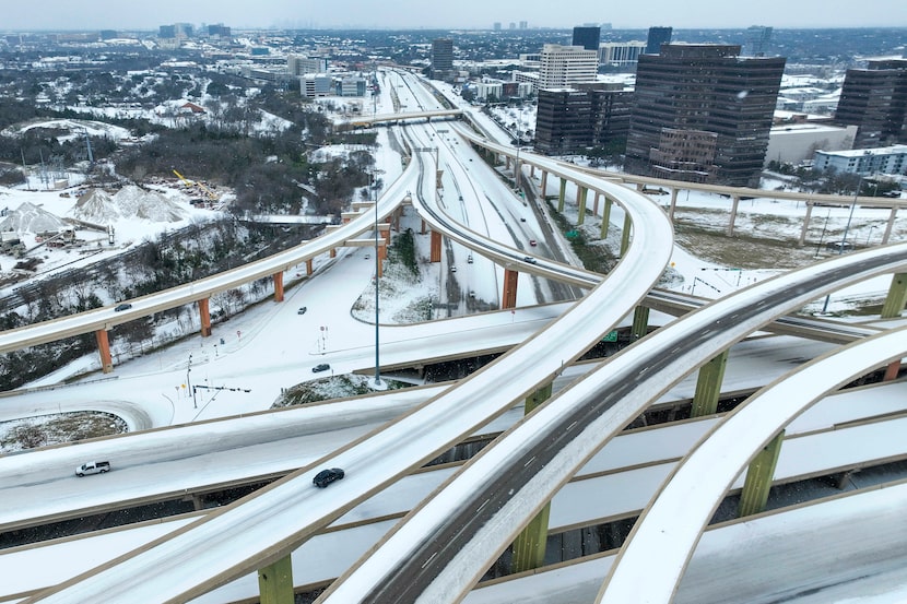 Motorists navigate an icy mix covering the High Five Interchange at US 75 and I-635 during a...