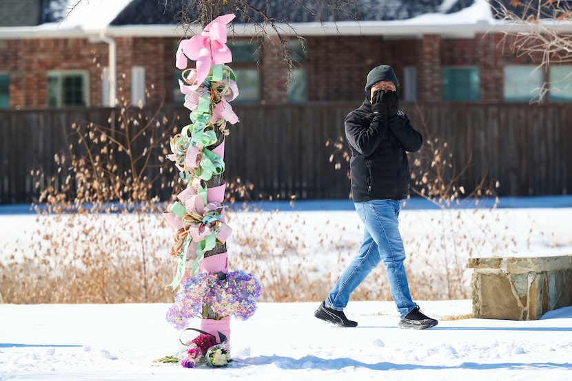 People pass by flowers and other remembrances at the site where two girls were involved in...
