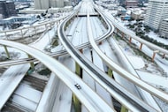 Motorists navigate an icy mix covering the High Five Interchange at US 75 and I-635 during a...