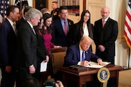 President Donald Trump signs the Laken Riley Act during an event in the East Room of the...