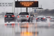 An ice prevention operations warning sign along southbound Interstate 35E is reflected in...