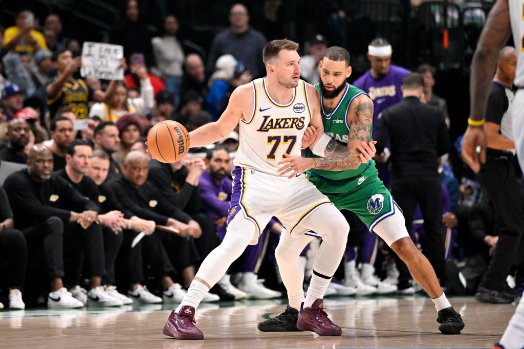 Los Angeles Lakers player Luka Doncic dribbling the ball against a Dallas Mavericks player.