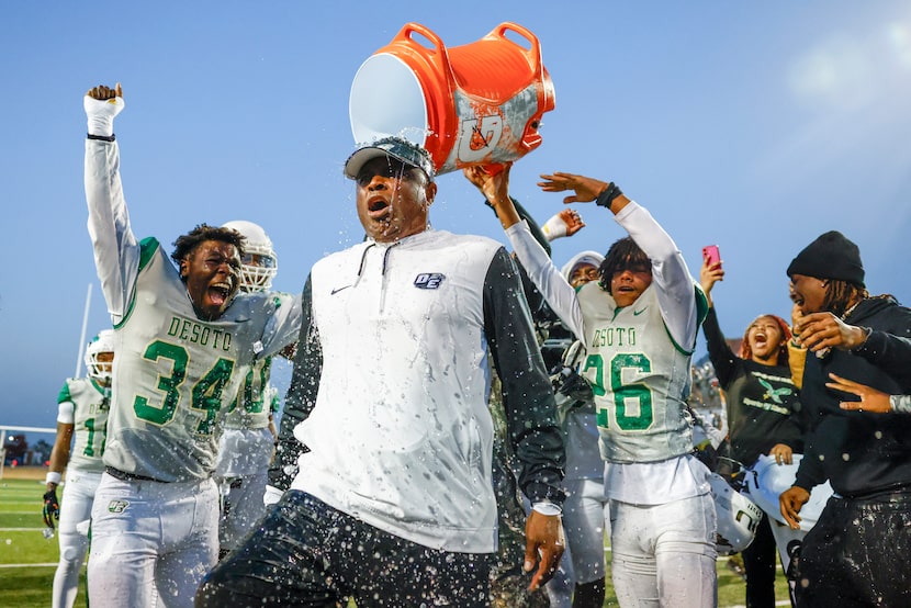 DeSoto head coach Claude Mathis is doused with water after winning a Class 6A Division II...