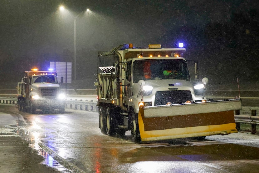 A TxDOT snowplow and brine truck drive along a frontage road near Interstate 30 and Beach...