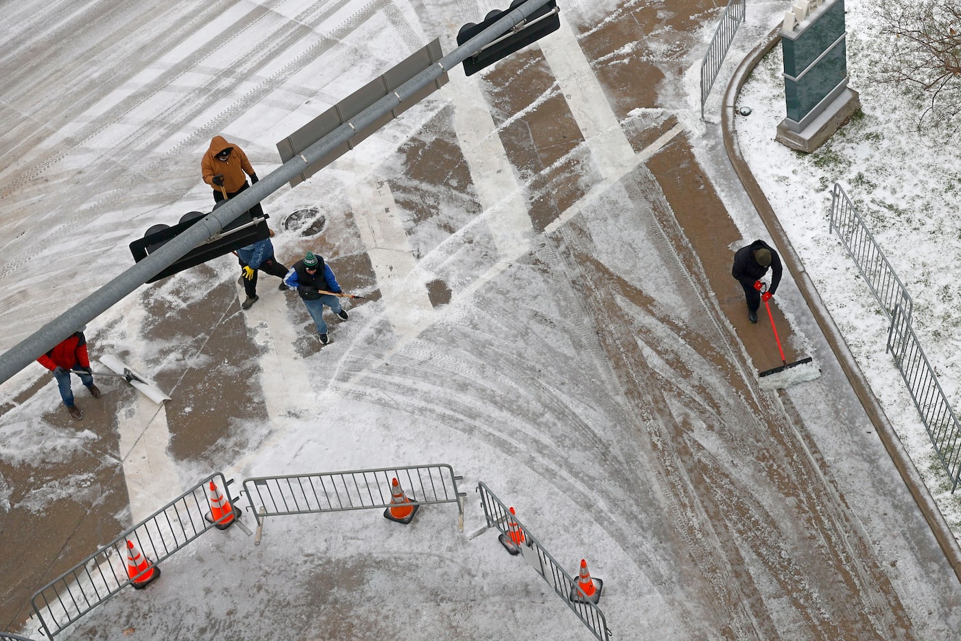 Workers clear snow in front of the Comerica Parking Garage before an NBA basketball game...