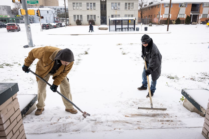 Joe Hernandez, right, helps his landlord clear ice from steps outside of an apartment...