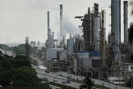 Vehicles drive past the El Palito refinery in Puerto Cabello, Venezuela, Sunday, Dec. 21,...