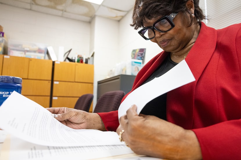 Director Gwendolyn Sneed flips through letters of endorsement from parents of students at...