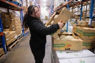 Warehouse stocker Ana Garcia puts jumbo cantaloupes from Costa Rica onto a pallet at the...
