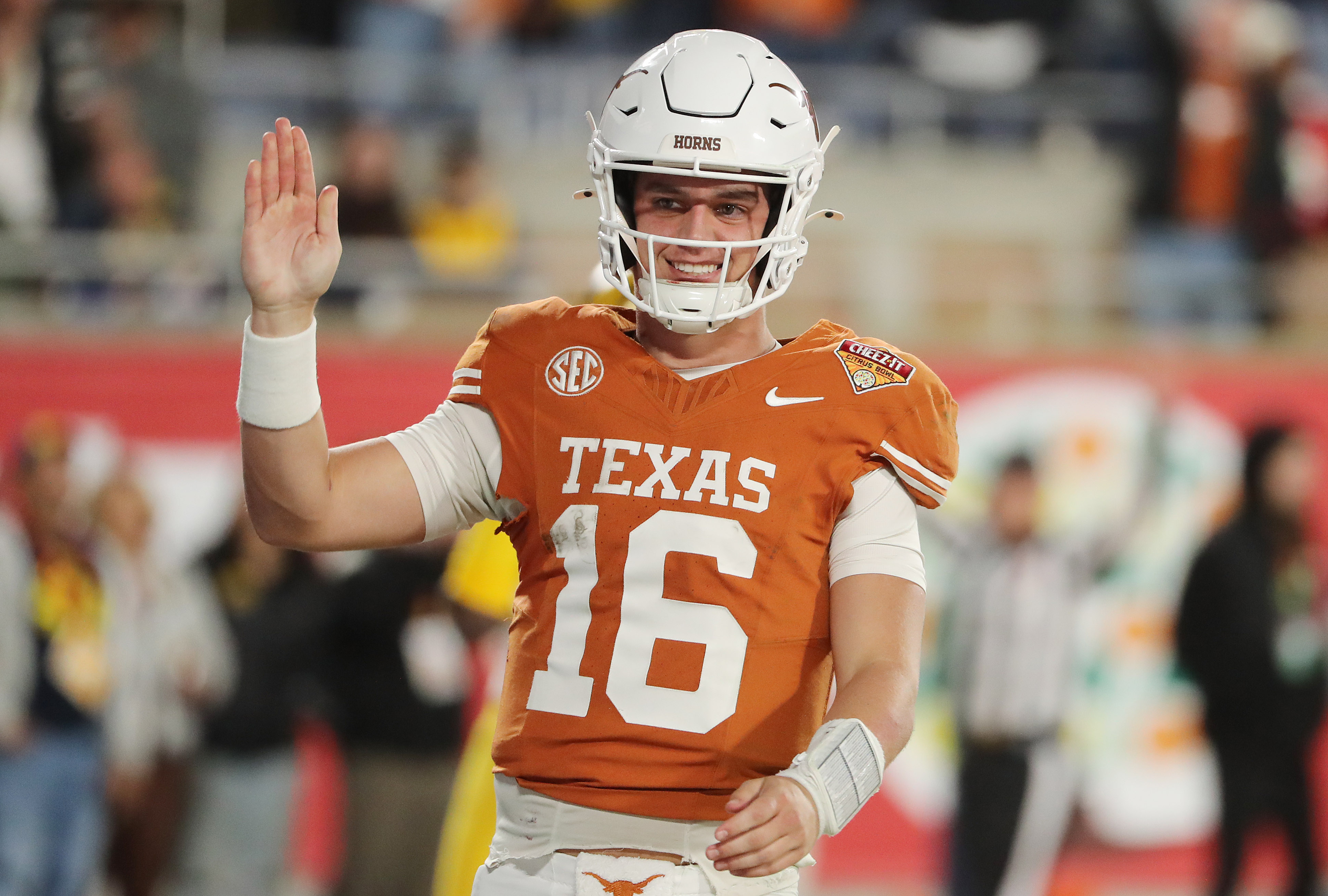 Texas quarterback Arch Manning waves to fans after running for...