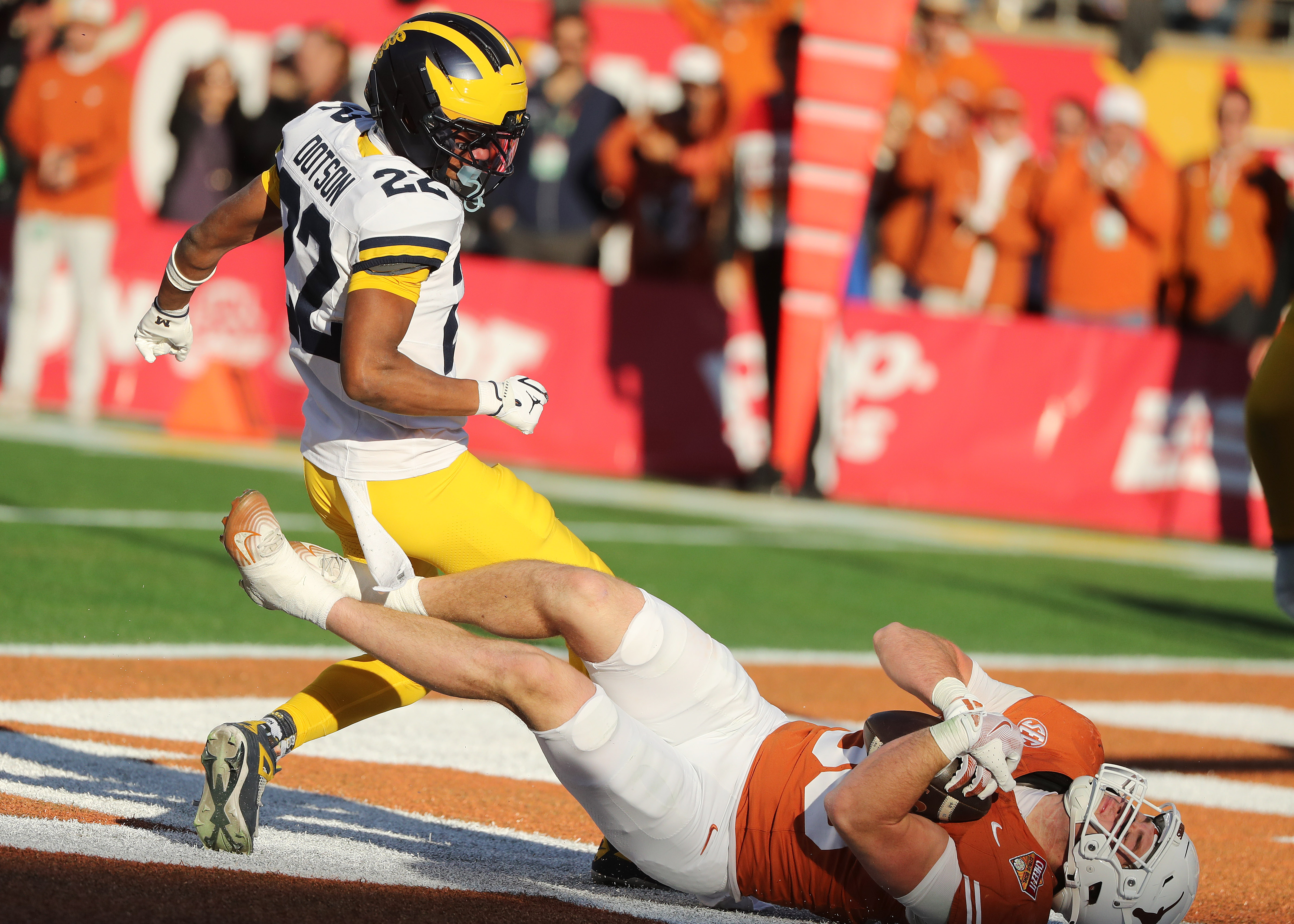 Texas tight end jack Endries (bottom) hangs on to a...