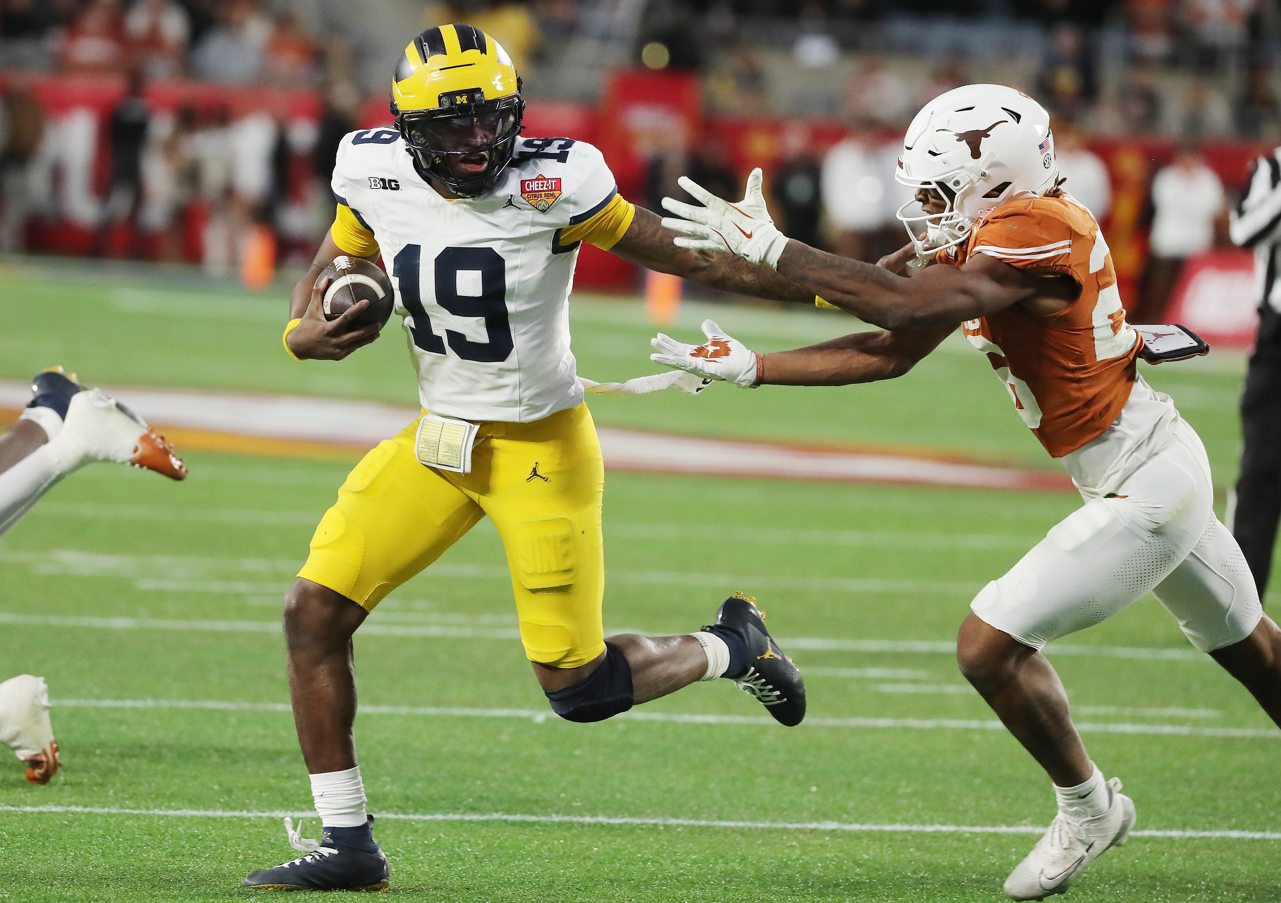 Michigan quarterback Bryce Underwood (19) shoves aside Texas linebacker Ty'Anthony...