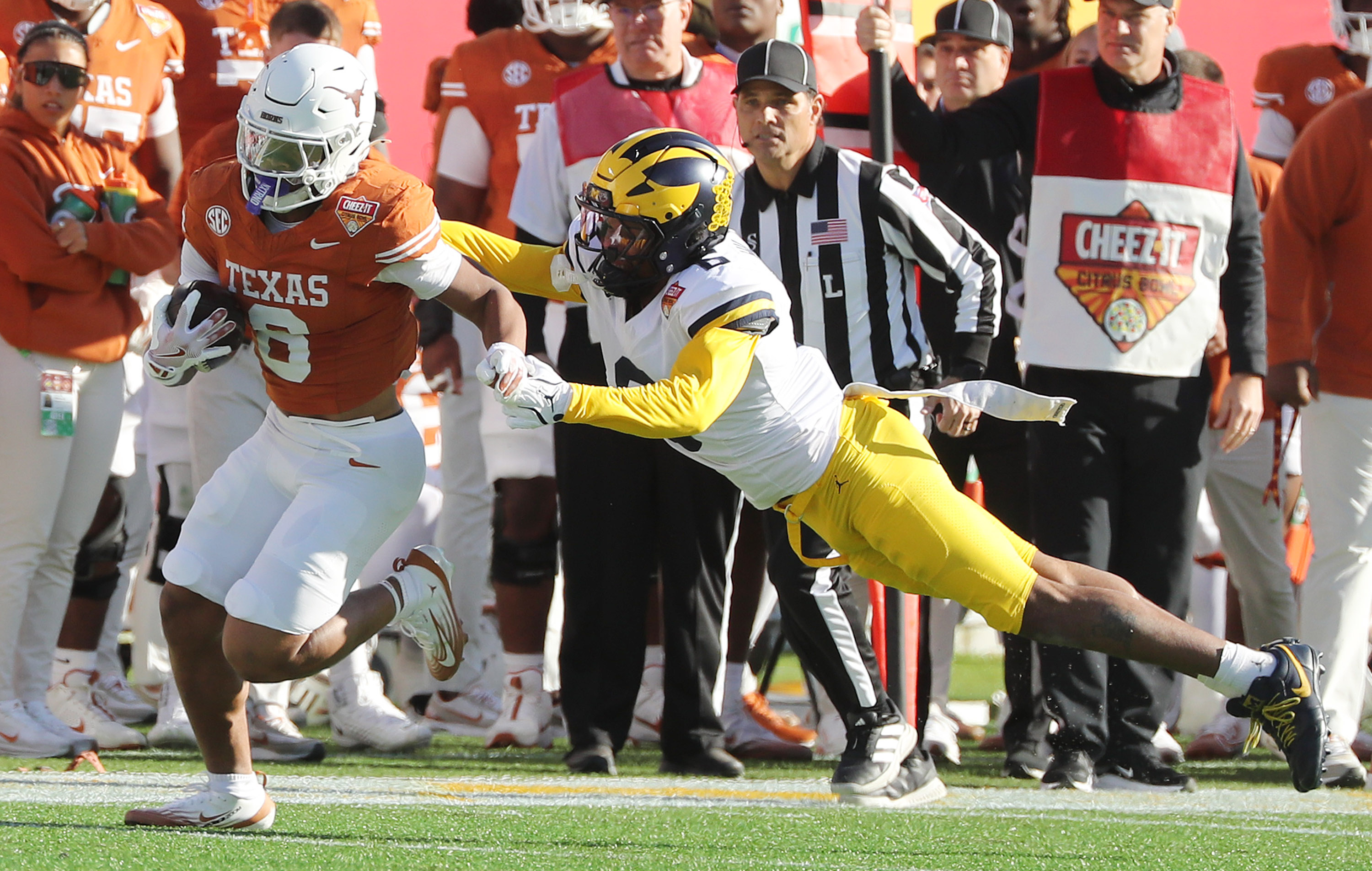 Texas running back Christian Clark (left) evades Michigan defensive back...