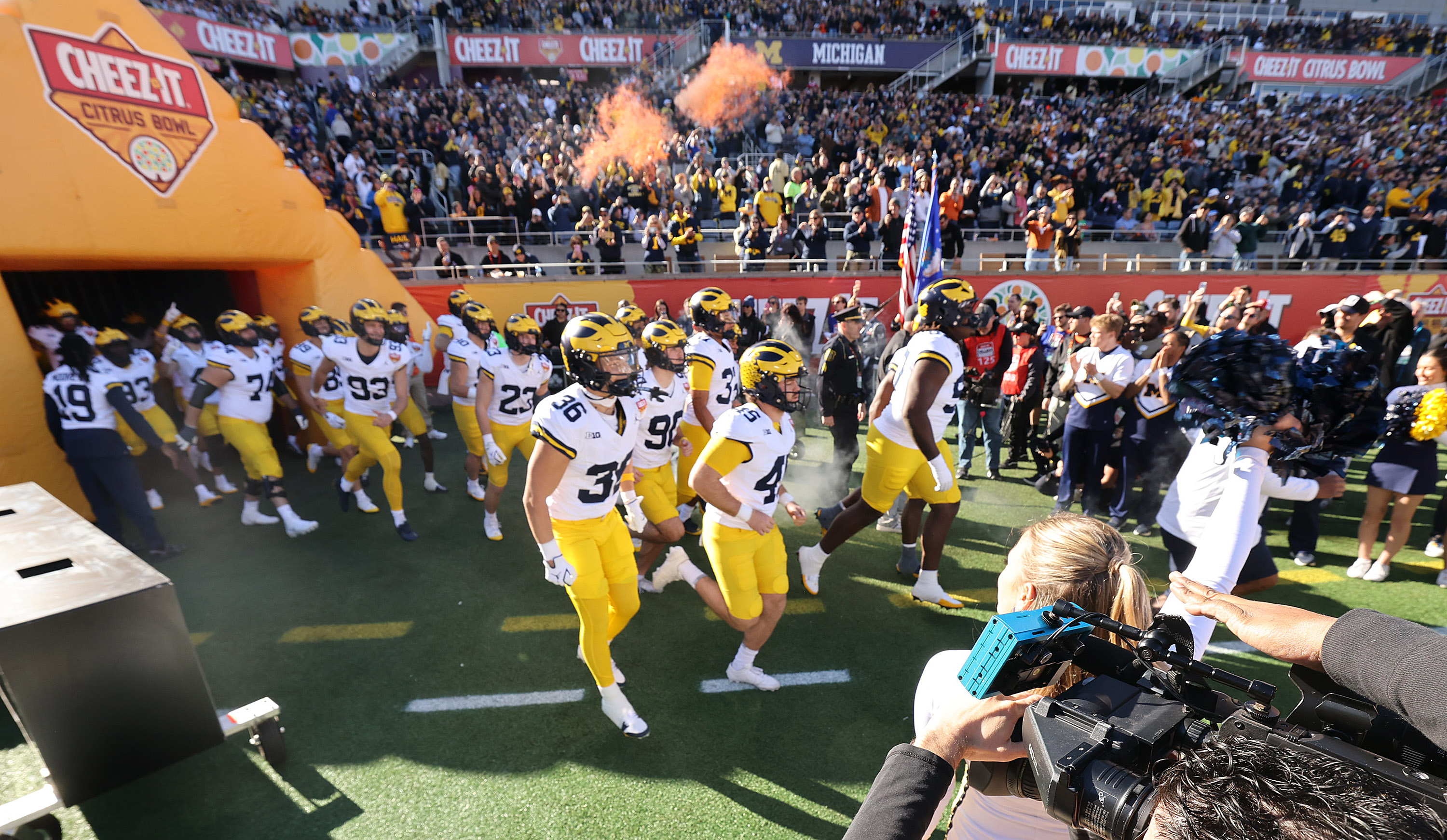 Michigan players run onto the field for the Cheez-It Citrus...