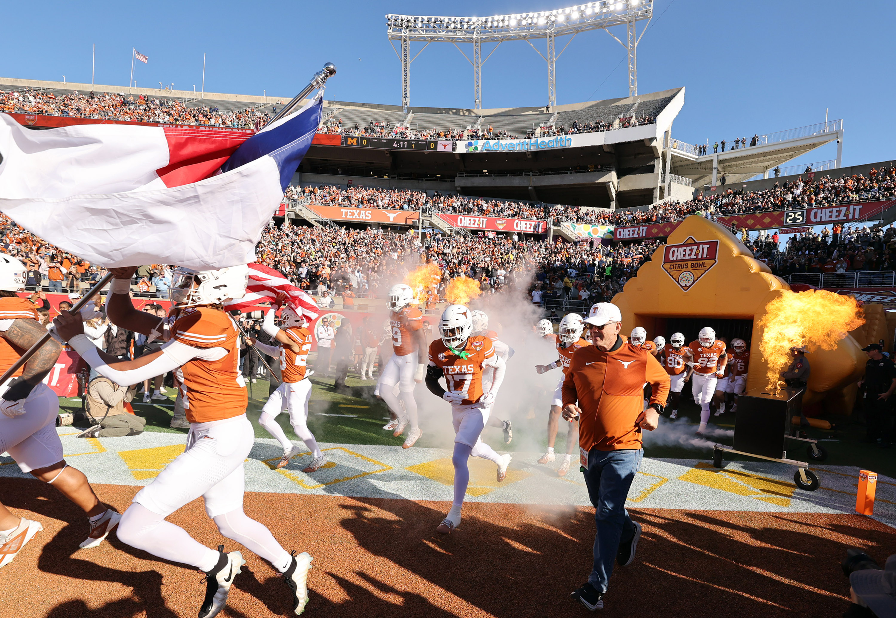 Texas players run onto the field for the Cheez-It Citrus...