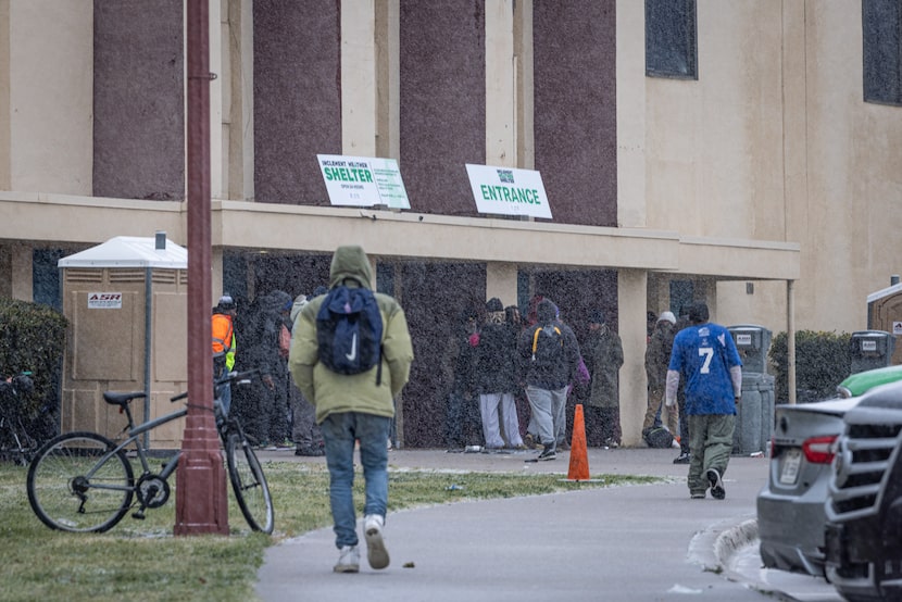 People seek shelter from sleet at the inclement weather shelter at Fair Park on Saturday,...
