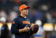 Denver Broncos defensive backs coach Jim Leonhard walks on the field before an NFL football...