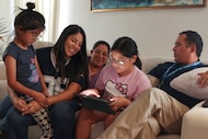 Lily Saracay, center, demonstrates how she practices Spanish using Duolingo as her family...