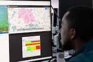 Meteorologist Troy Anderson has weather maps pulled while working inside of the newly...
