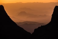 A brilliant sunset is seen through The Window at Chisos Basin in Big Bend National Park. A...