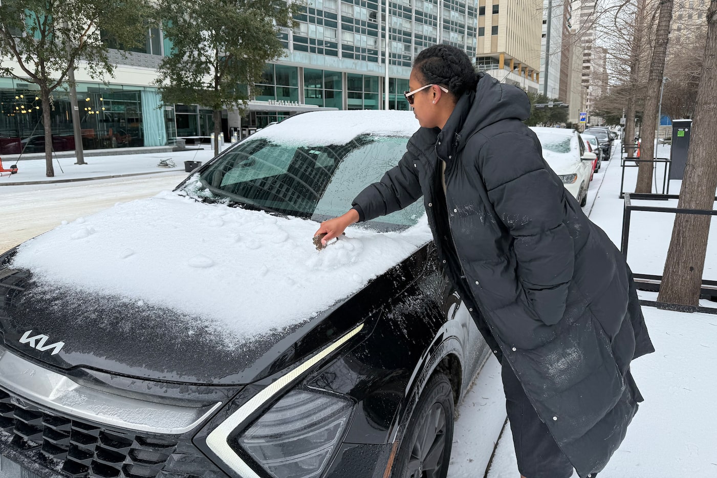 Victoria White of Oklahoma scrapes ice off her windshield downtown Dallas,  Sunday, Jan. 25,...
