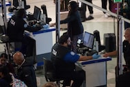 TSA workers check in passengers at the security checkpoint at Dallas Love Field airport in...