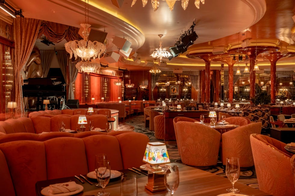 Elegant dining area with plush seating and a stage for performances.