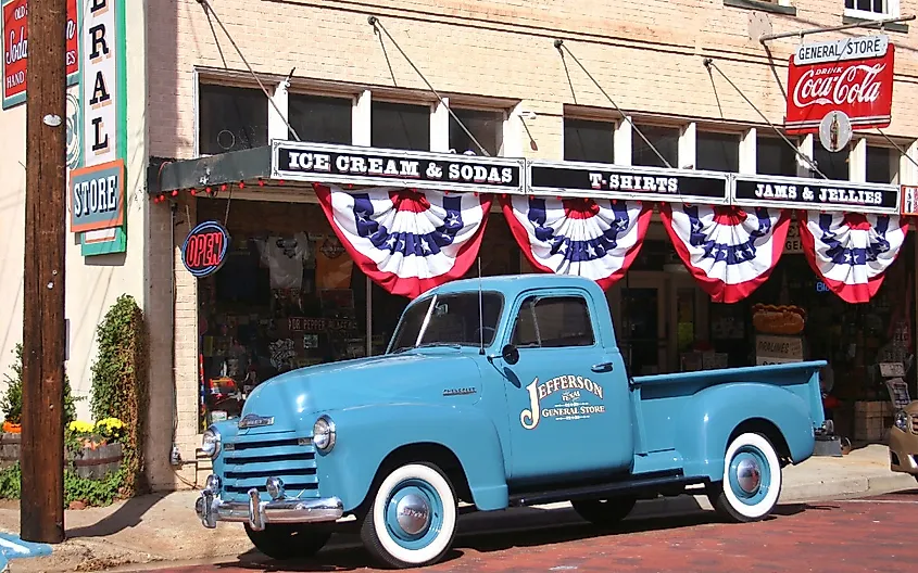 Old blue truck parked int front of historic Jefferson General Store located in downtown Jefferson, Texas