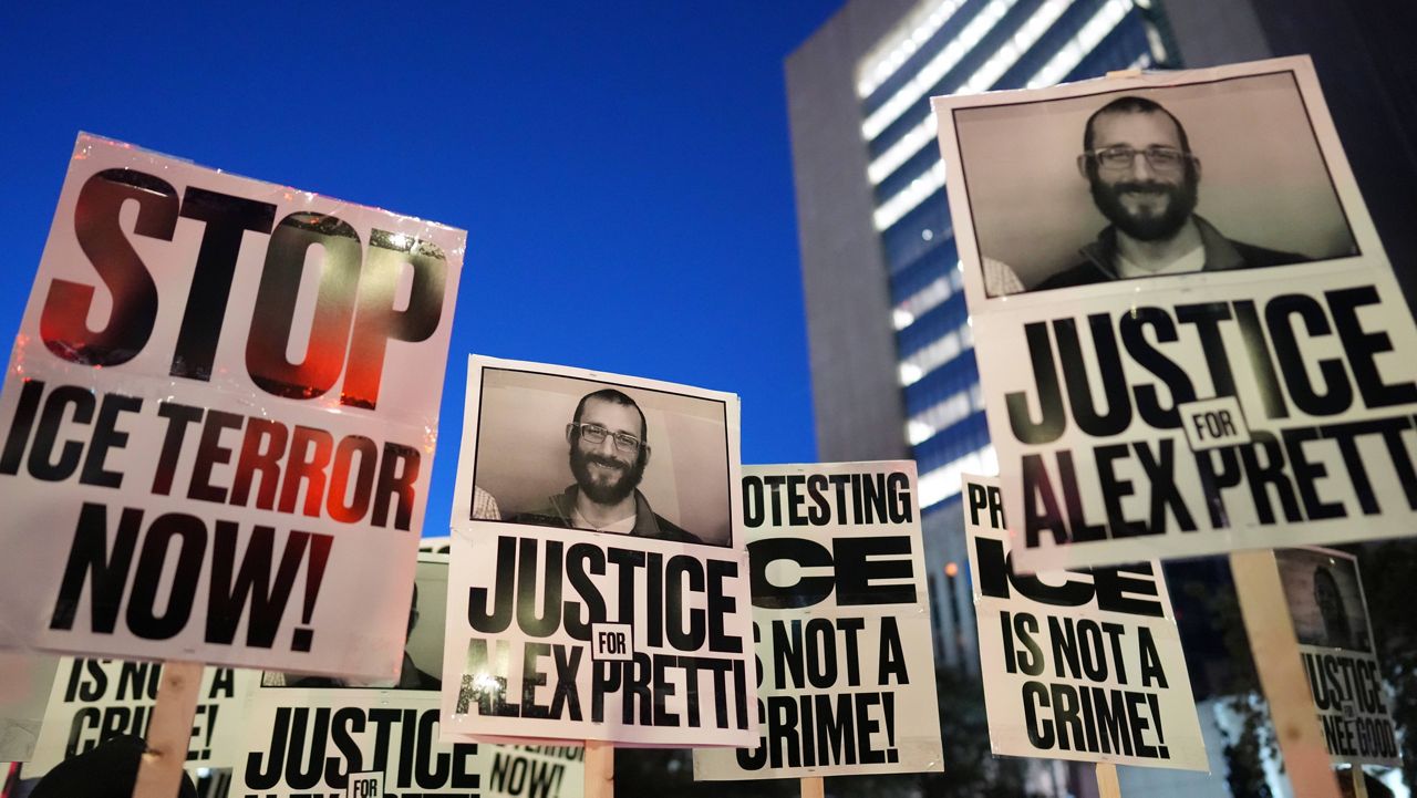 Demonstrators hold signs during a rally against federal immigration enforcement at Federal Courthouse Plaza on Tuesday, Jan. 27, 2026, in Minneapolis. (AP Photo/Adam Gray)