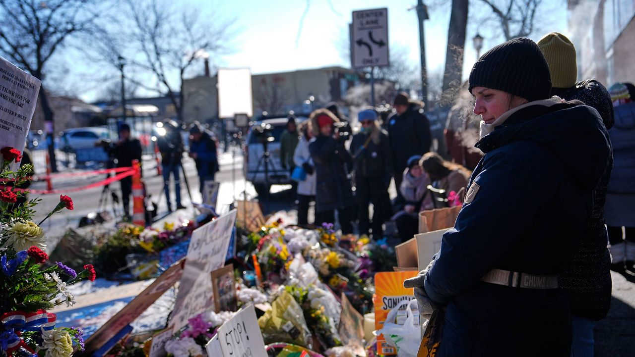 People visit a memorial for Alex Pretti at the scene where the 37-year-old was fatally shot by a U.S. Border Patrol officer over the weekend, Tuesday, Jan. 27, 2026, in Minneapolis. (AP Photo/Julia Demaree Nikhinson)