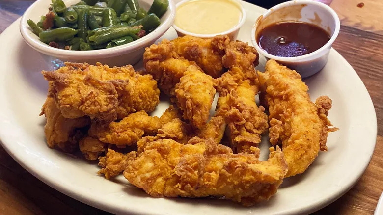 Plate of Texas Roadhouse Chicken Critters with green beans and dipping sauce