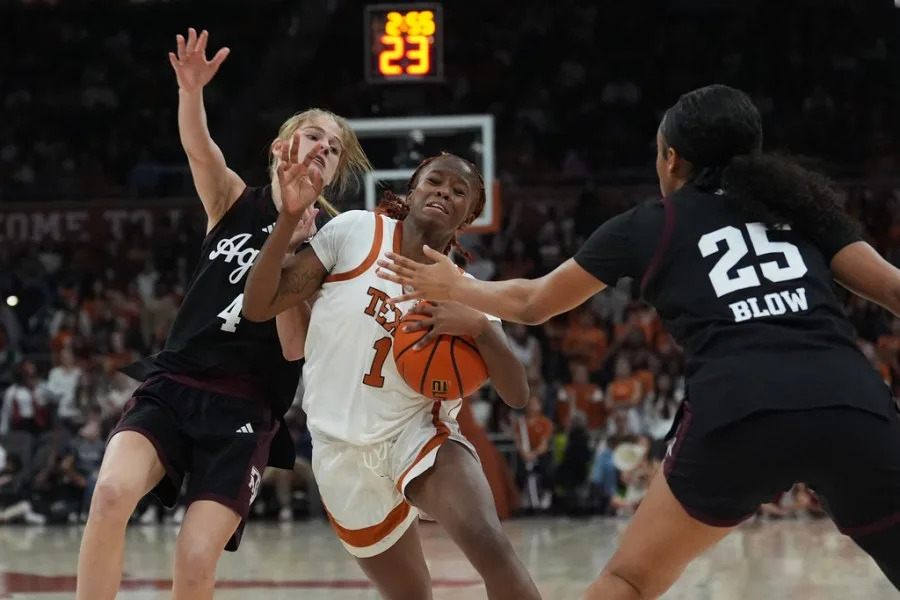 Texas guard Bryanna Preston (1) is fouled as she drives against Texas A&M guard Chaney Spencer (4) and guard Salese Blow (25) during the second half of an NCAA college basketball game in Austin, Texas, Sunday, Jan. 18, 2026. (AP Photo/Eric Gay)