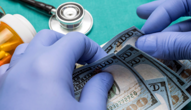 A picture of a stethoscope with gloved hands counting money.