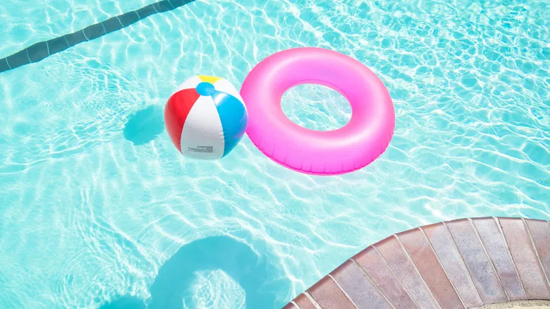 Beach ball and lifesaver for kids in blue swimming pool