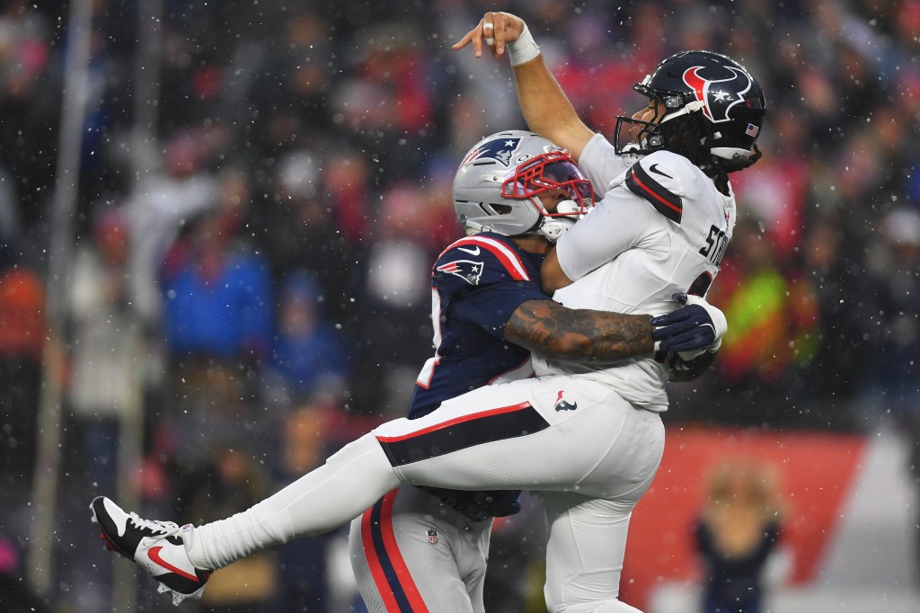 New England Patriots linebacker K'lavon Chaisson hitting Houston Texans quarterback C.J. Stroud during a playoff football game.