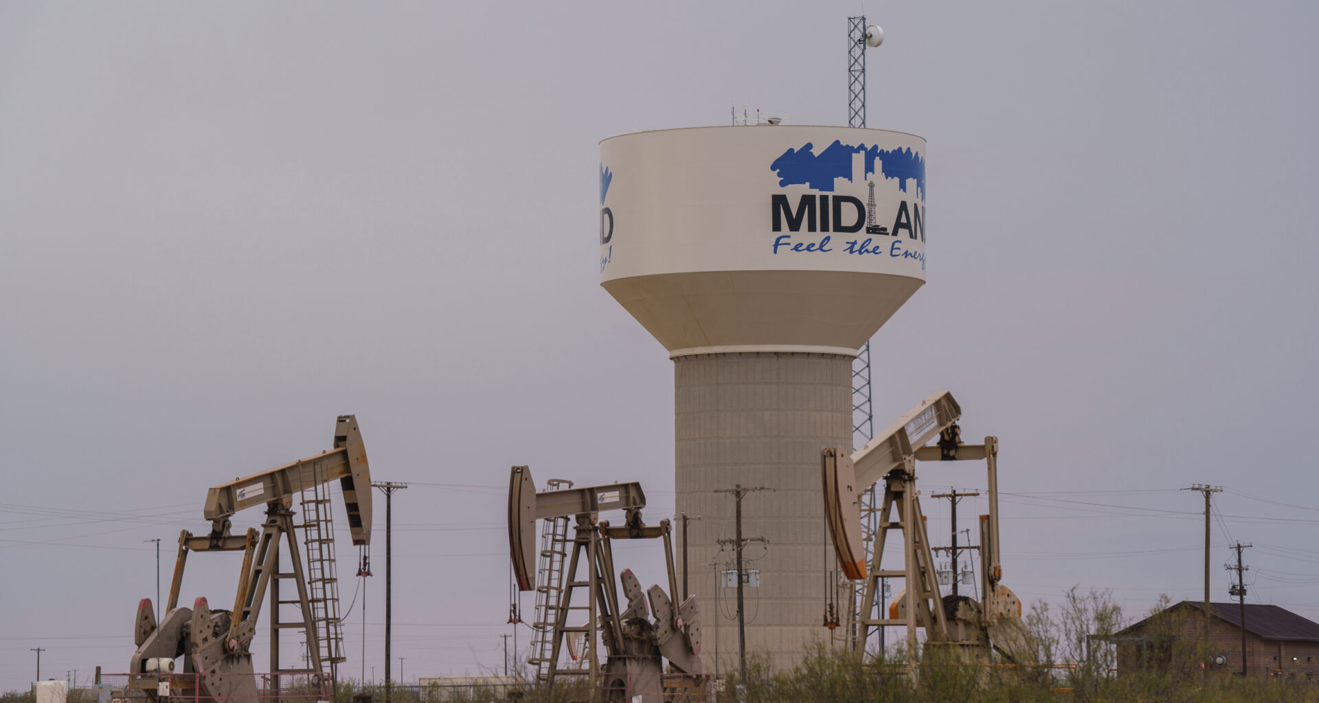 A water pipeline from the T-Bar Ranch terminates at this water tower on the western side of Midland, Texas, where oil pump jacks operate. Credit: Paul Ratje/Inside Climate News